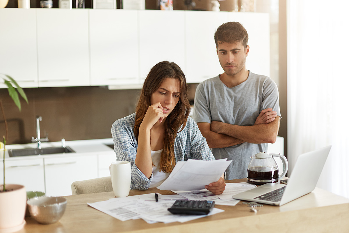 candid-shot-young-american-man-woman-dressed-casually-feeling-stressed-while-managing-finances-1200